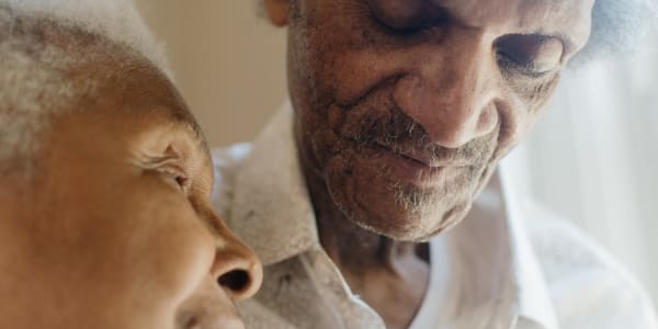 Resident couple looking out a window together at Bell Tower Residence Assisted Living in Merrill, Wisconsin