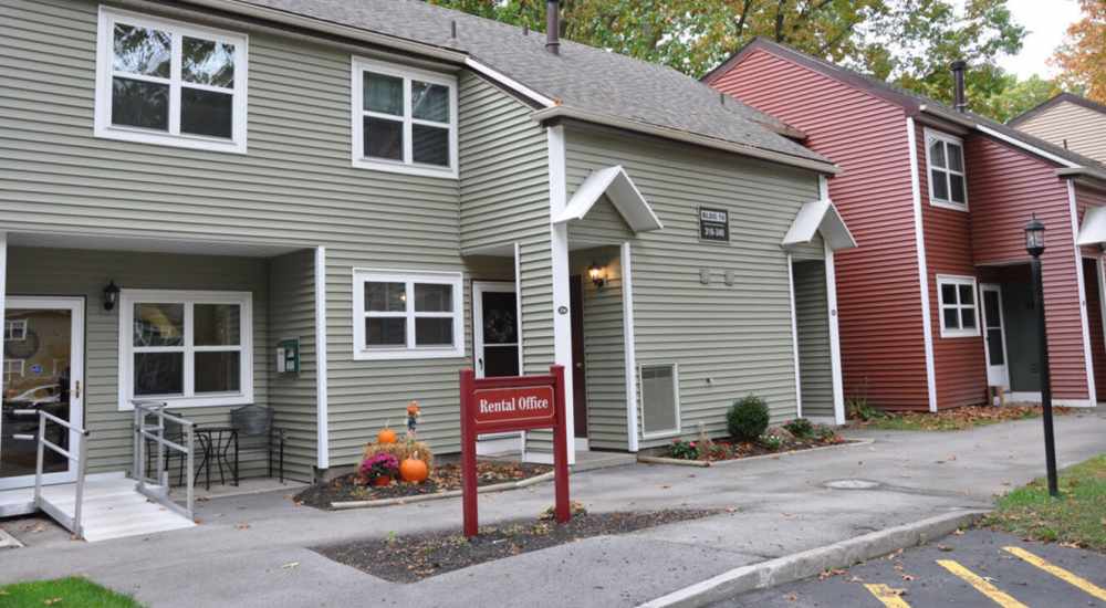 Charming rental office with welcoming entrance and landscaped surroundings at Woodland Estates in East Rochester, New York