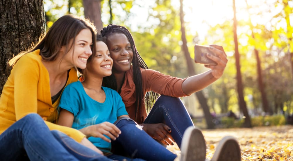 Family taking a selfie outdoors at Bellrock Market Station in Katy, Texas