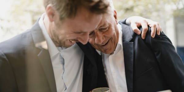 Resident looking through a scrapbook with his younger son at Fair Oaks Health Care Center in Crystal Lake, Illinois