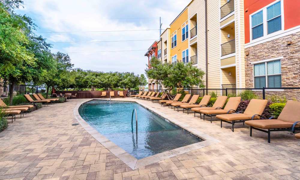 Community pool with a sun loungers by the deck at Grapevine Station in Grapevine,Texas