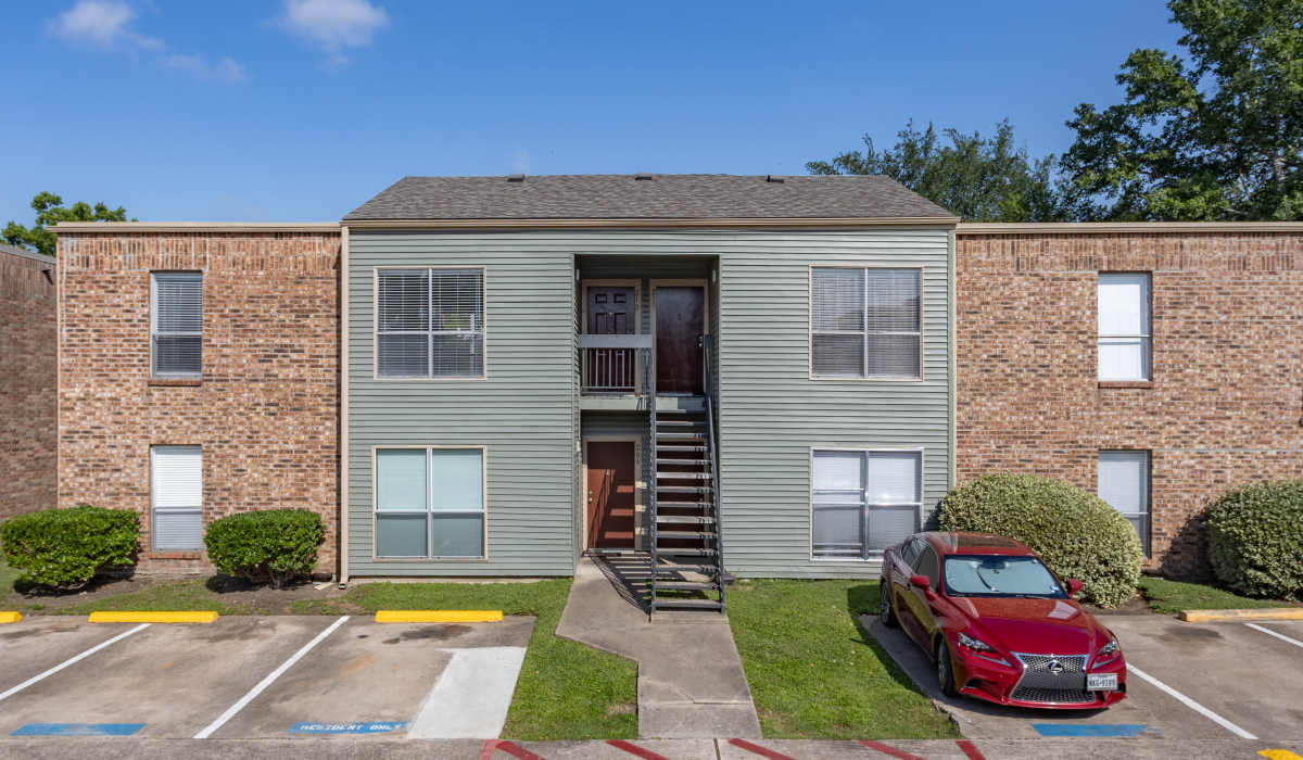 Exterior view of apartments with parking at University Green Apartments in Houston, Texas