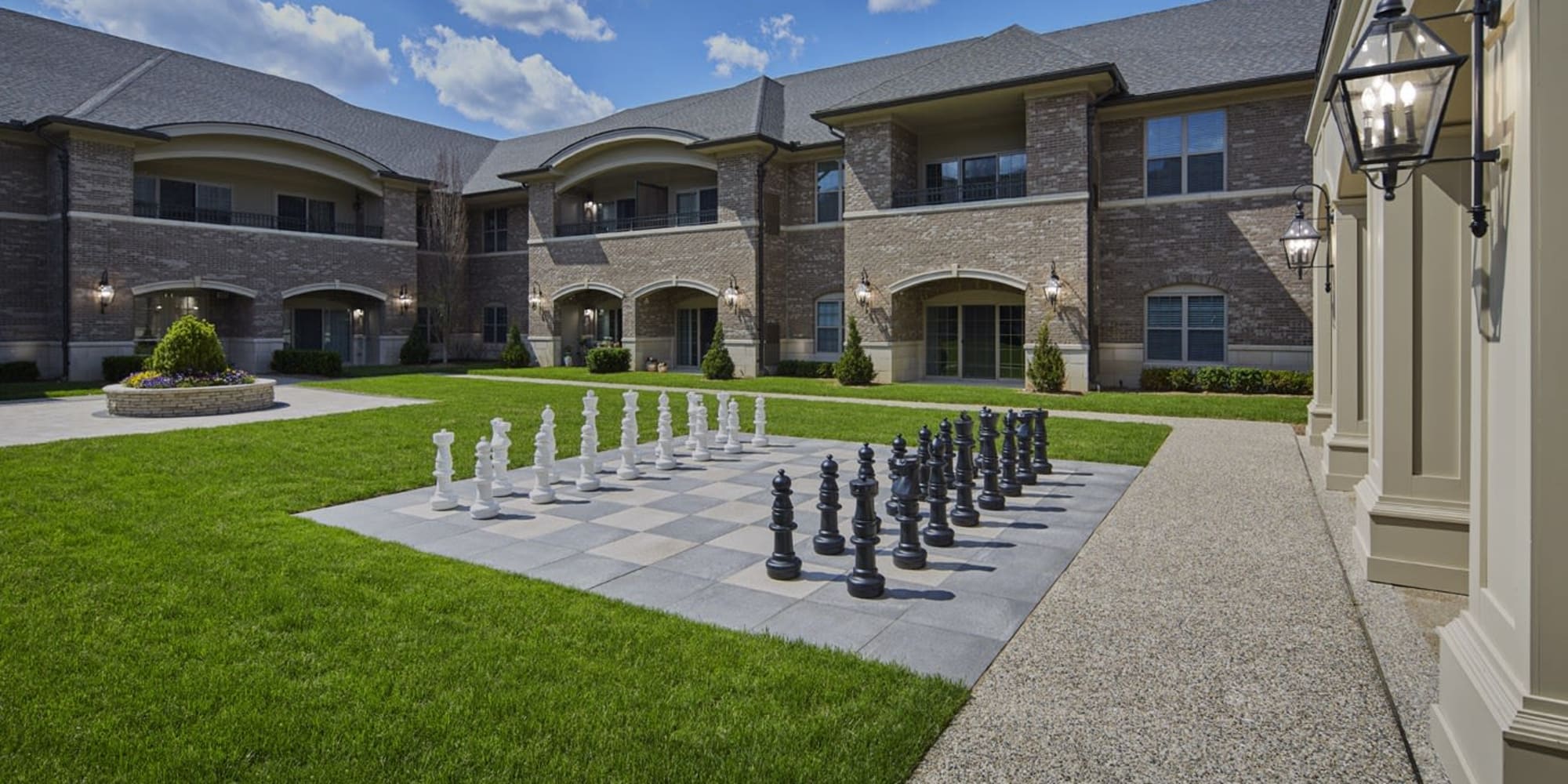 Encircled courtyard with walking paths and a giant chess set at Blossom Ridge in Oakland Charter Township, Michigan