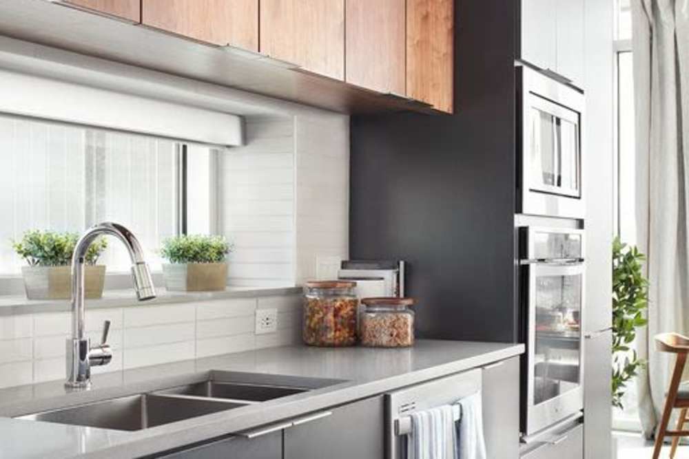 Kitchen with stainless steel appliances , sink and storage units at Ardan in Dallas, Texas