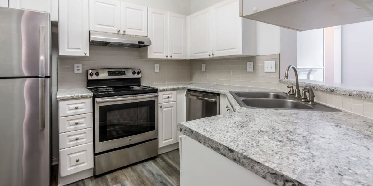 Bright kitchen with wood flooring and stainless steel appliances at Marquis at Sugarloaf in Duluth, Georgia