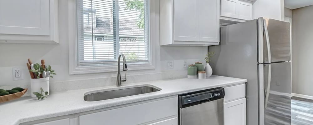 Modern kitchen with granite countertops, refrigerator and wooden cabinets at Woodside Village in Valparaiso, Indiana