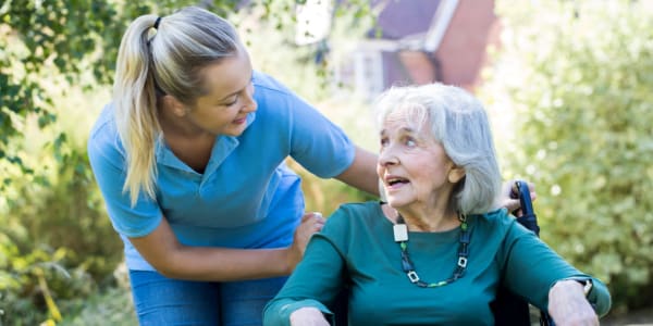 Two residents sitting side-by-side on a bench at East Troy Manor in East Troy, Wisconsin