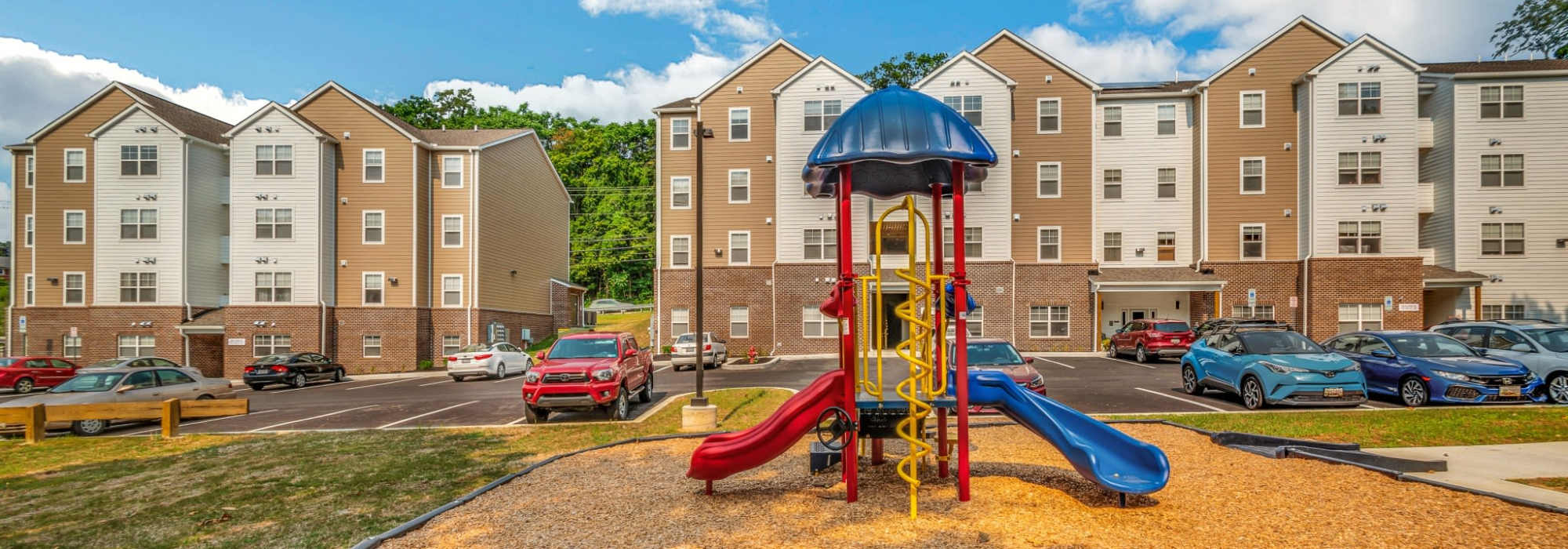 Play structure with apartments in the background at Magnolia Greene in Lavale, Maryland