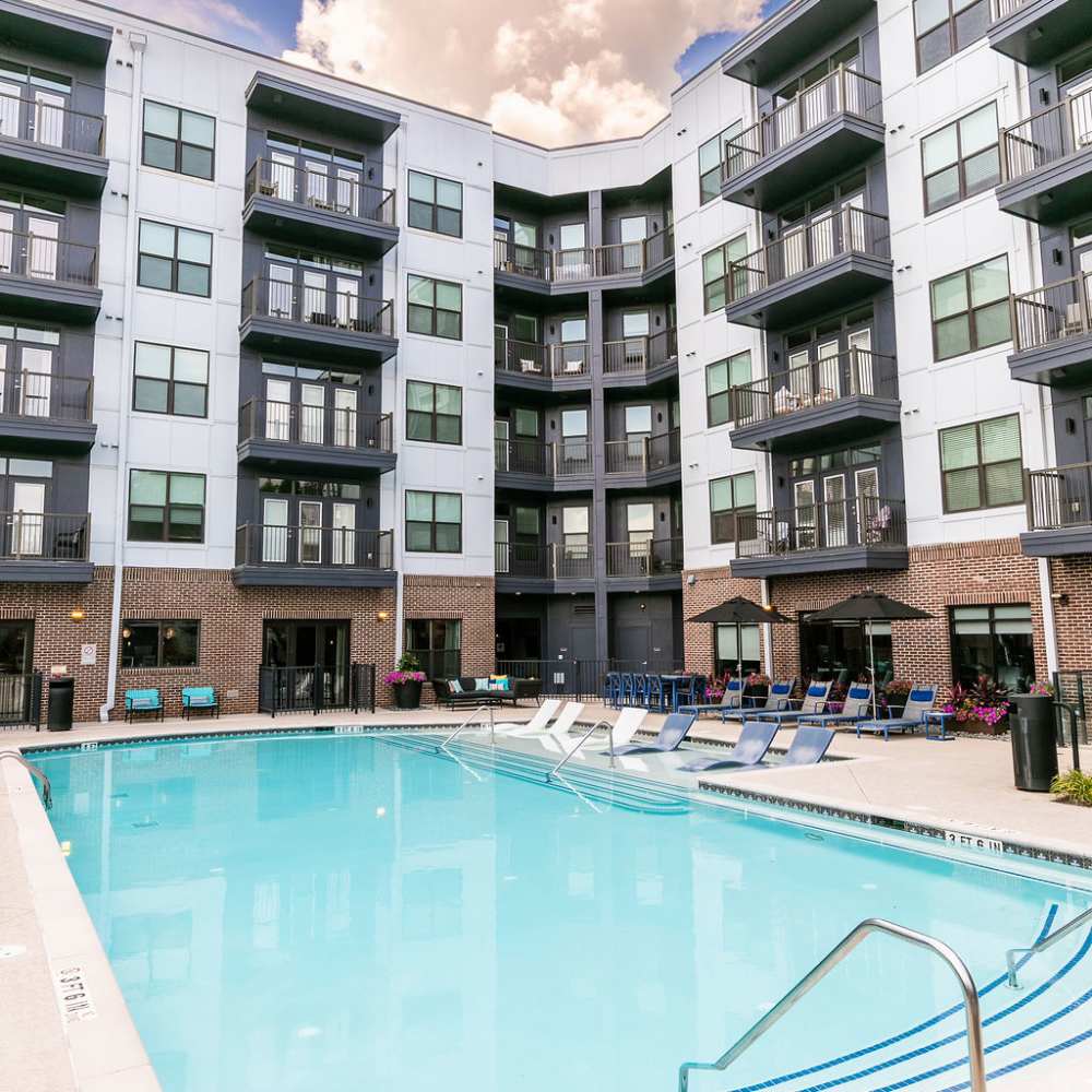 Exterior of apartment building with view of the swimming pool at Siena Suwanee Town Center in Suwanee, Georgia