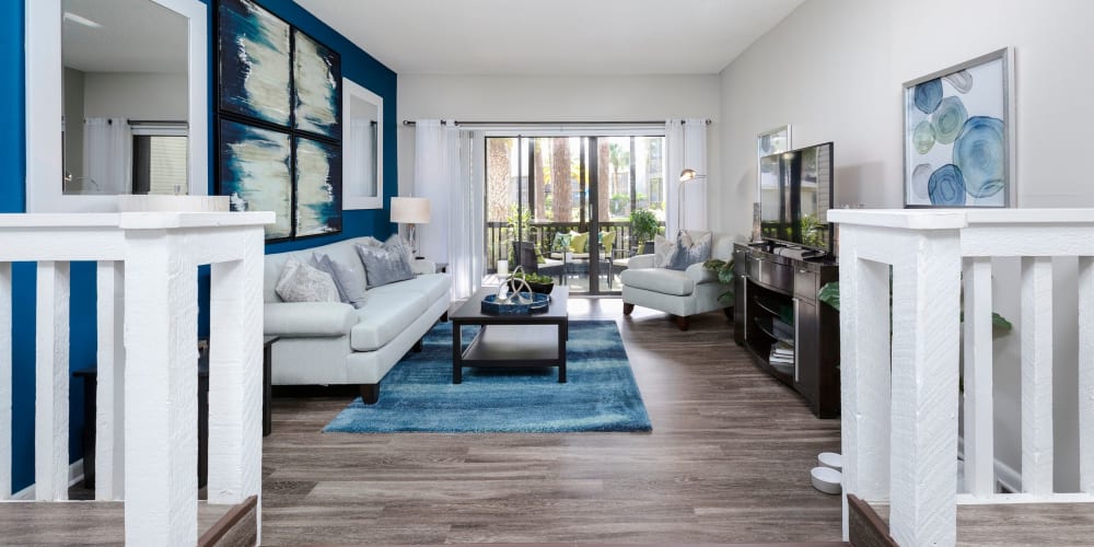 Large living room with wood floors and patio access at Enclave at Lake Ellenor in Orlando, Florida