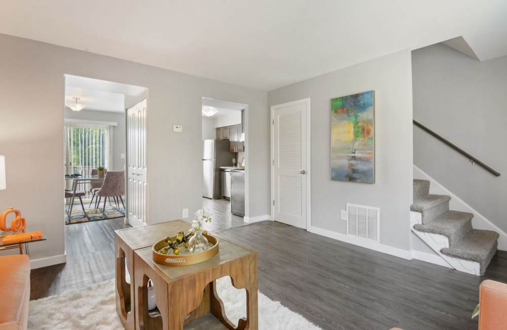 Bright living area with wood-style flooring, modern decor, and open layout leading to kitchen and dining space at Fairway Ridge in Baltimore, Maryland