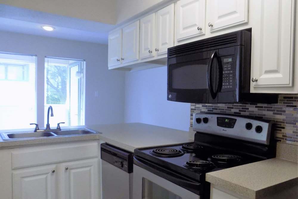 Apartment kitchen with modern appliances at Branch Creek Apartments in Carrollton, Texas