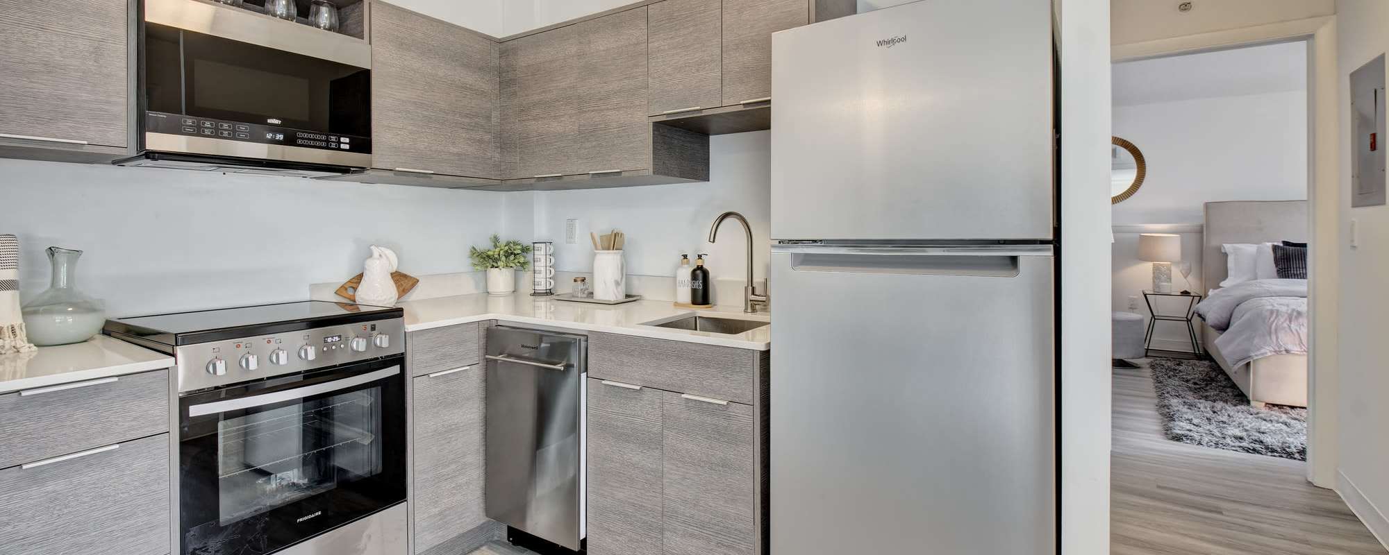 Kitchen with refrigerator at The Nora in Dallas, Texas