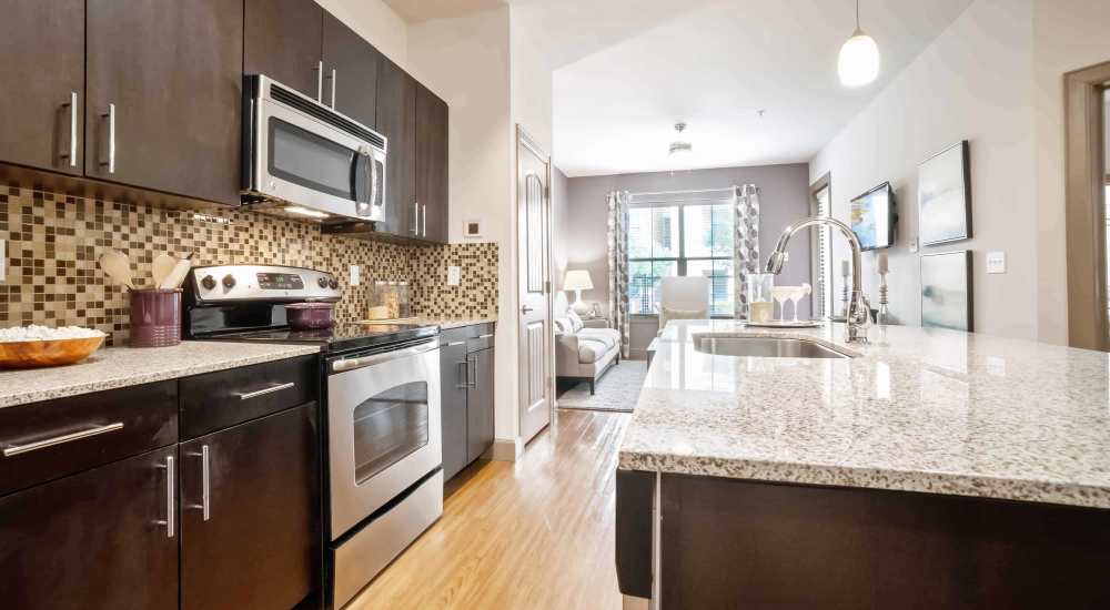 Cozy kitchen with dark colored cabinetry and bright walls at Grapevine Station in Grapevine, Texas