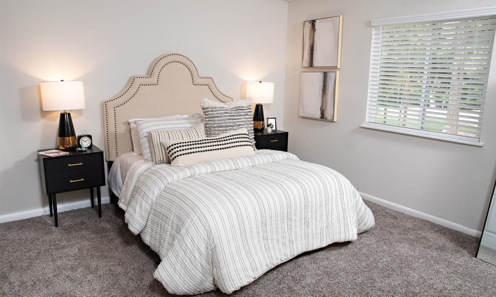 A furnished bedroom with plush carpeting at Dwell at Carmel in Charlotte, North Carolina