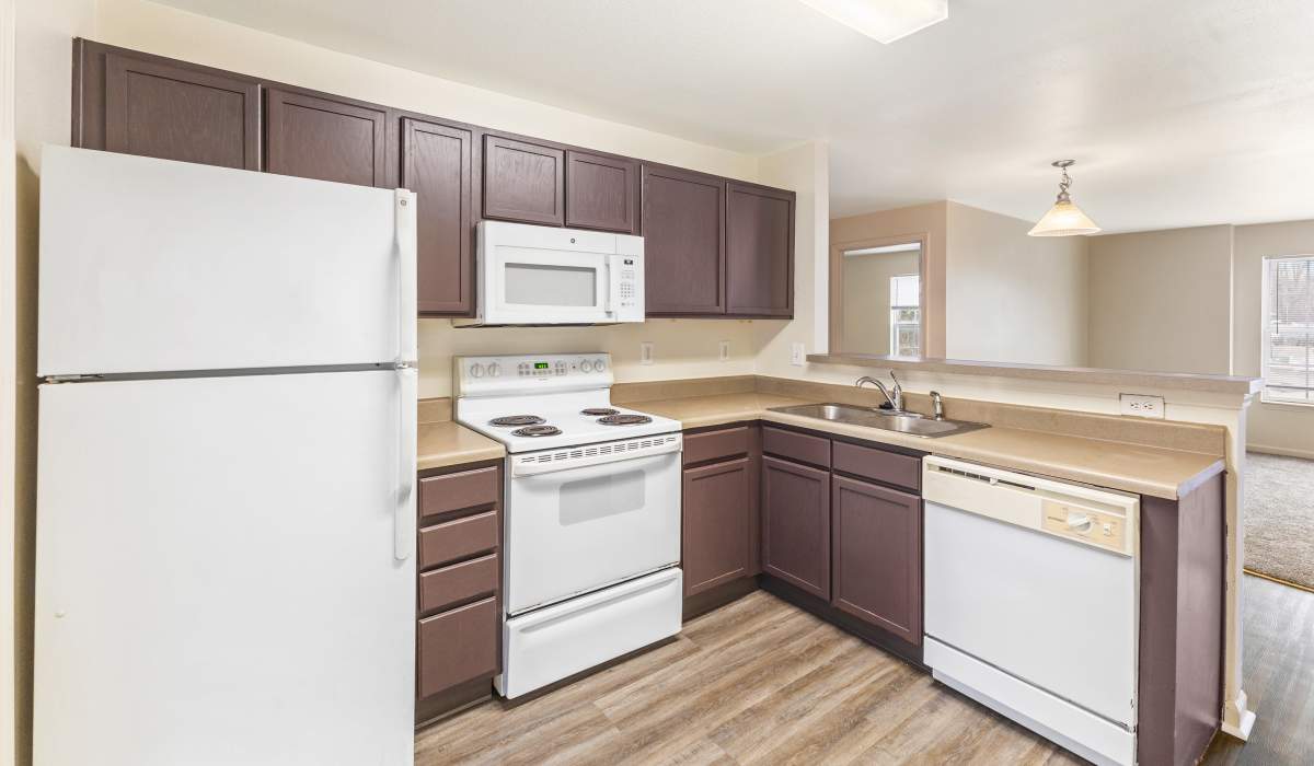 Modern kitchen with wooden cabinets at Northampton Village Apartments in Indianapolis, Indiana