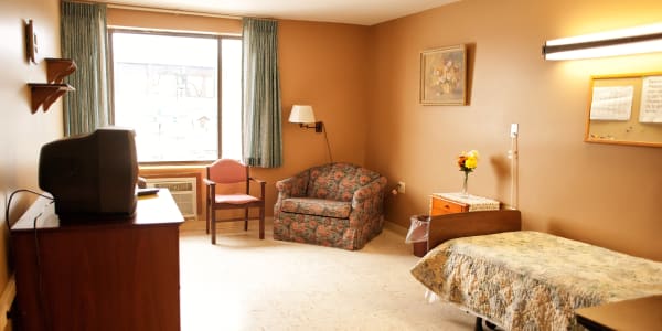 Resident room with reading nook and tv at East Troy Manor in East Troy, Wisconsin