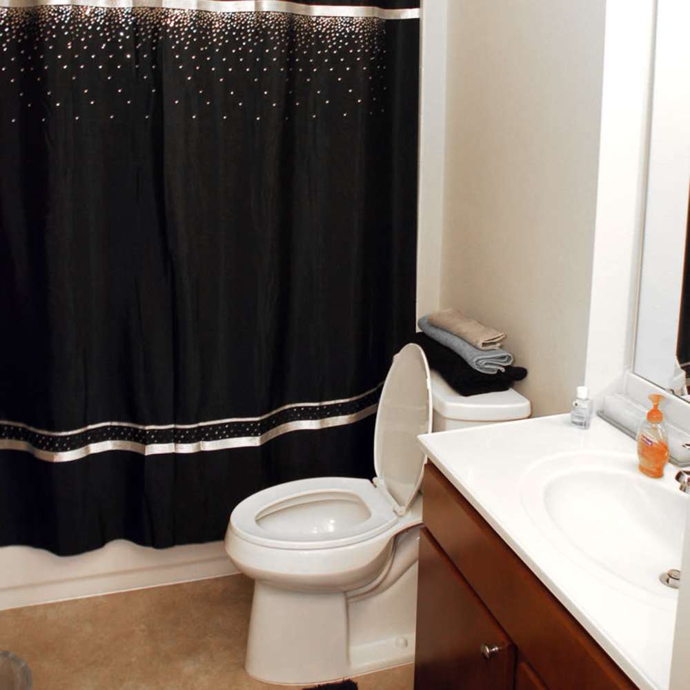 Bathroom with a bathtub and shower curtains at Council Tower Apartments in Saint Louis,Missouri