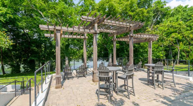 Outdoor patio with wooden pergola and seating in a lush green park at The Banks at West Fork in Murfreesboro, Tennessee