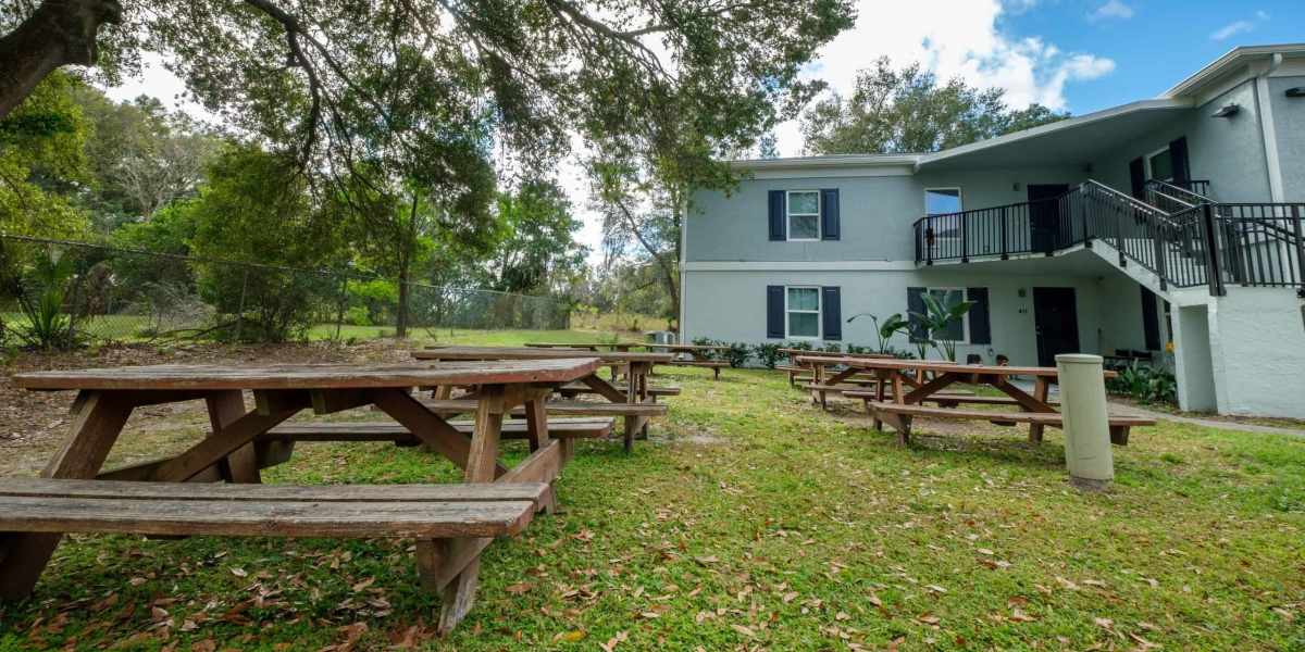 Wooden tables in lawn next to apartment home at Wayne Densch Center in Orlando, Florida