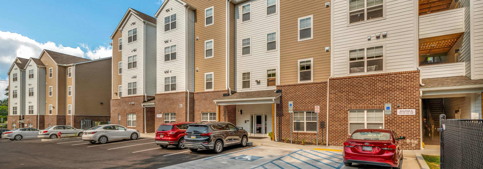 Exterior view of brick and tan apartment building at  Magnolia Greene in Lavale, Maryland