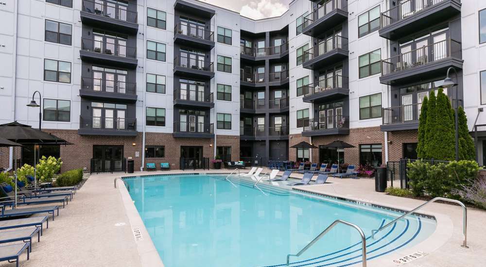 Resort-style swimming pool with lounge chairs at Siena Suwanee Town Center in Suwanee, Georgia