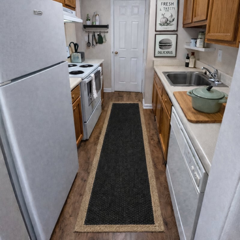 Charming modern kitchen featuring sleek appliances, warm wooden cabinetry, and inviting decor at High Point Crossing Apartments in Augusta, Georgia.