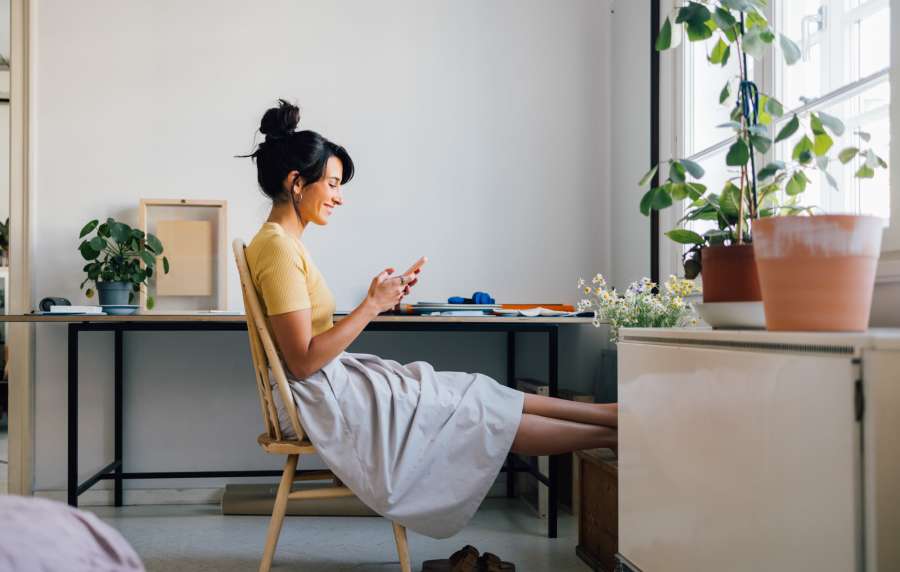 Woman sitting in home office, texting at Balcones Trails in Kyle, Texas