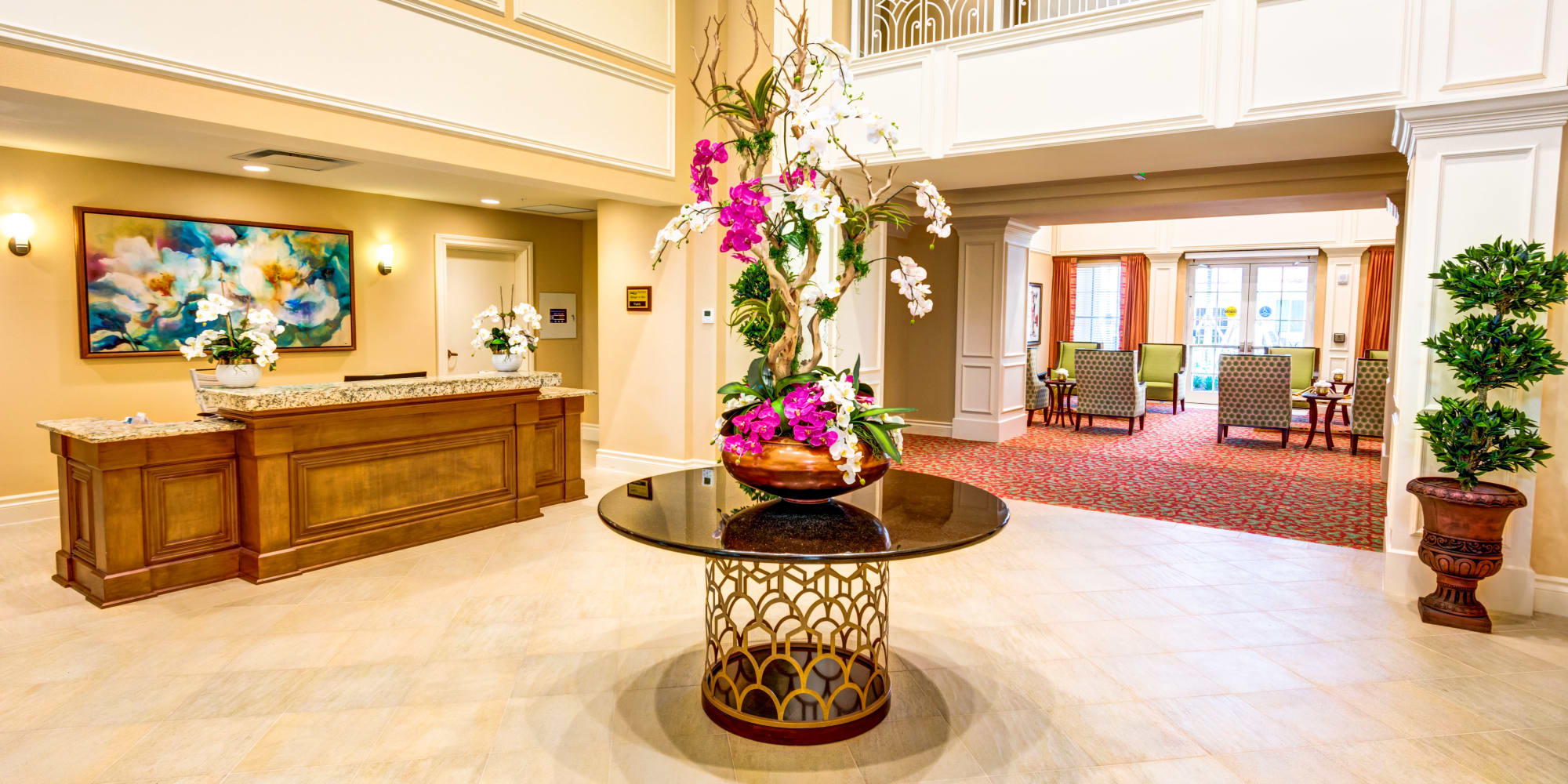 The Meridian at Boca Raton lobby with reception desk and center console table with large floral arrangement