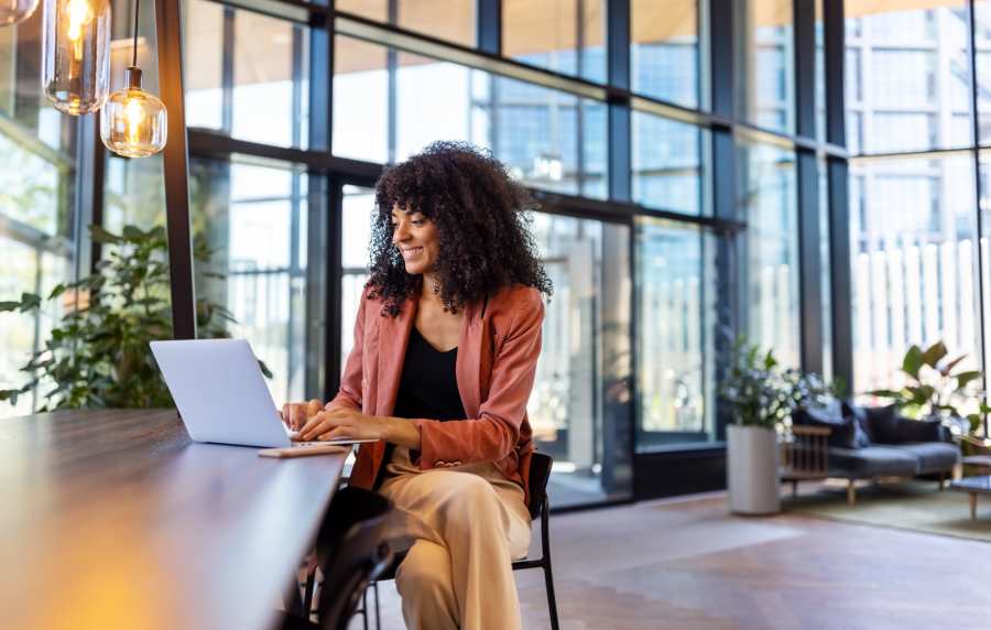 Woman working on laptop at communal workspace at Redwood in San Marcos, Texas