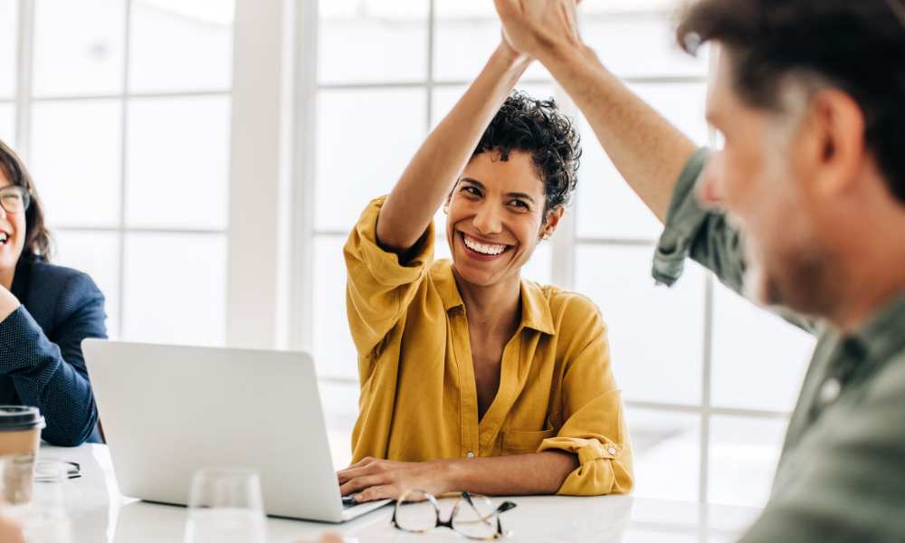Two employees high-fiving at Drucker + Falk in Newport News, Virginia