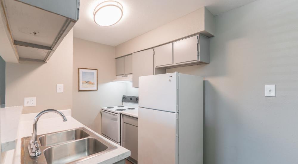 Kitchen with white appliances at The Grand 1501 in College Station, Texas