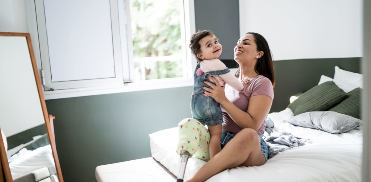 A mother holds her young child in her bedroom at Attain at Bradford Creek, Huntsville, Alabama