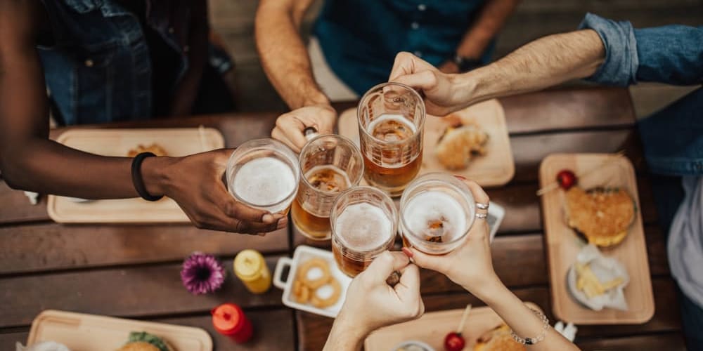 Group of people doing a cheers at a table near  Bayfair Apartments in San Lorenzo, California