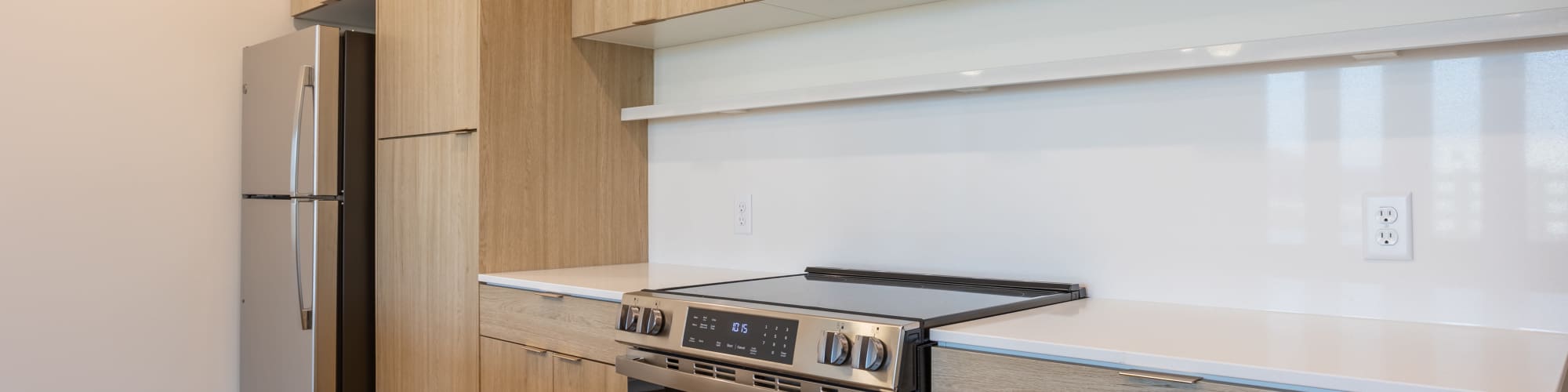 Kitchen with wooden cabinets and a refrigerator at Residences at 111 Lyon in Grand Rapids, Michigan