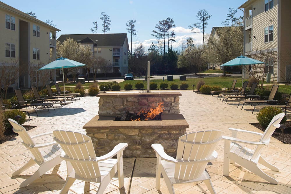 Outdoor fireplace with plenty of seating at Park Villas Apartments in Lexington Park, Maryland