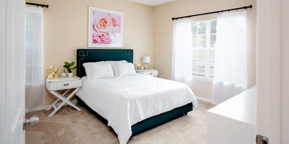 A well-decorated bedroom with comfortable bed and large window at Madison Park in Madison, Alabama