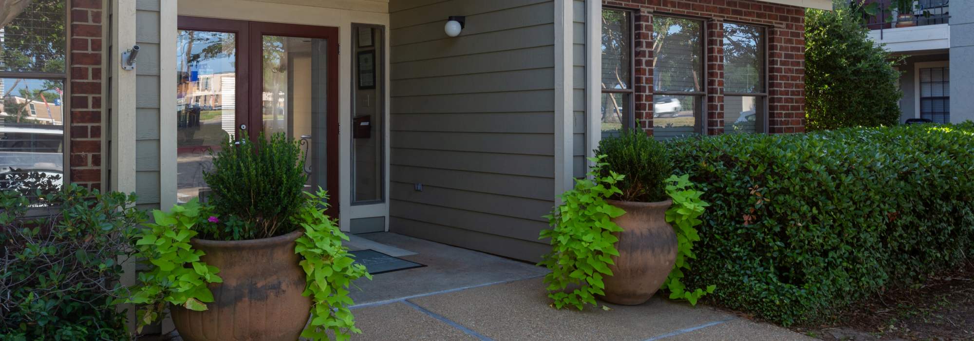 Exterior view of an apartment with potted plants at Southwood Village in Shreveport, Louisiana