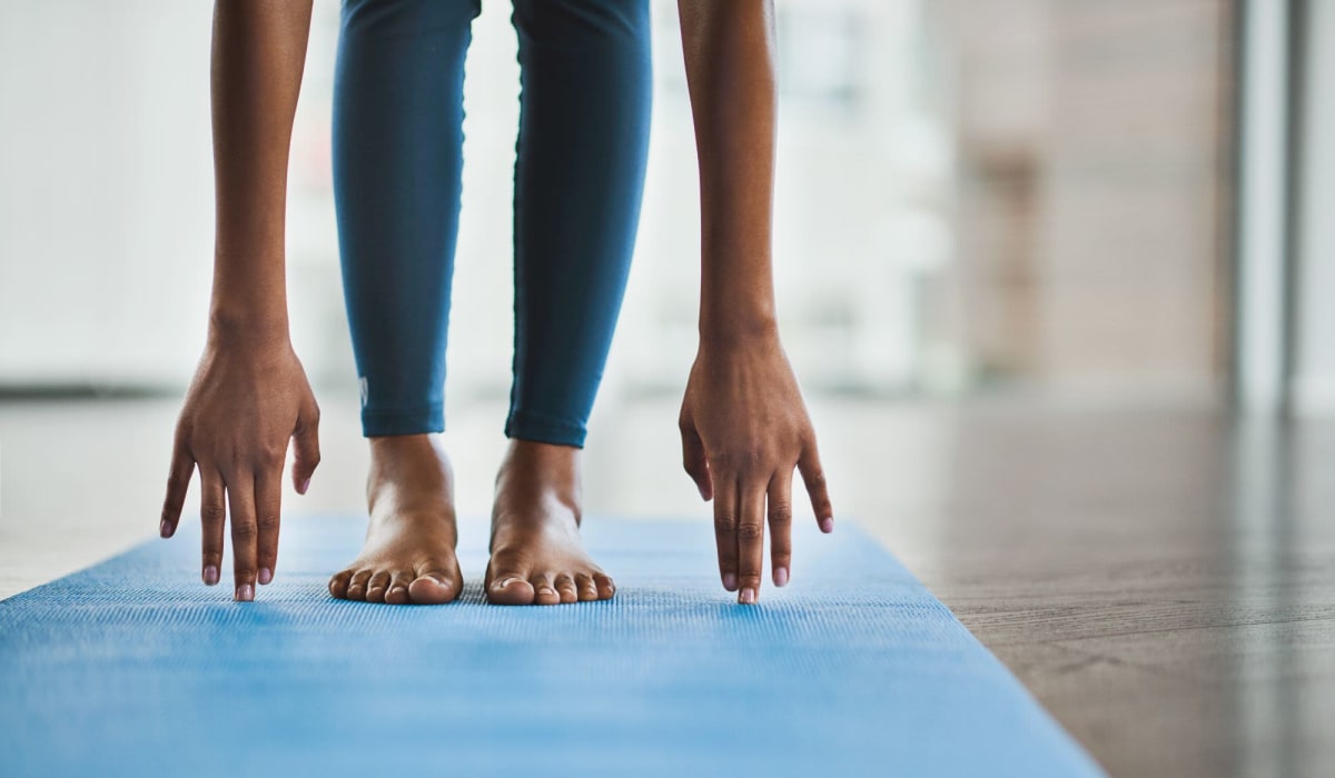 Resident doing yoga in the fitness center at Legacy at Cypress in Cypress, Texas