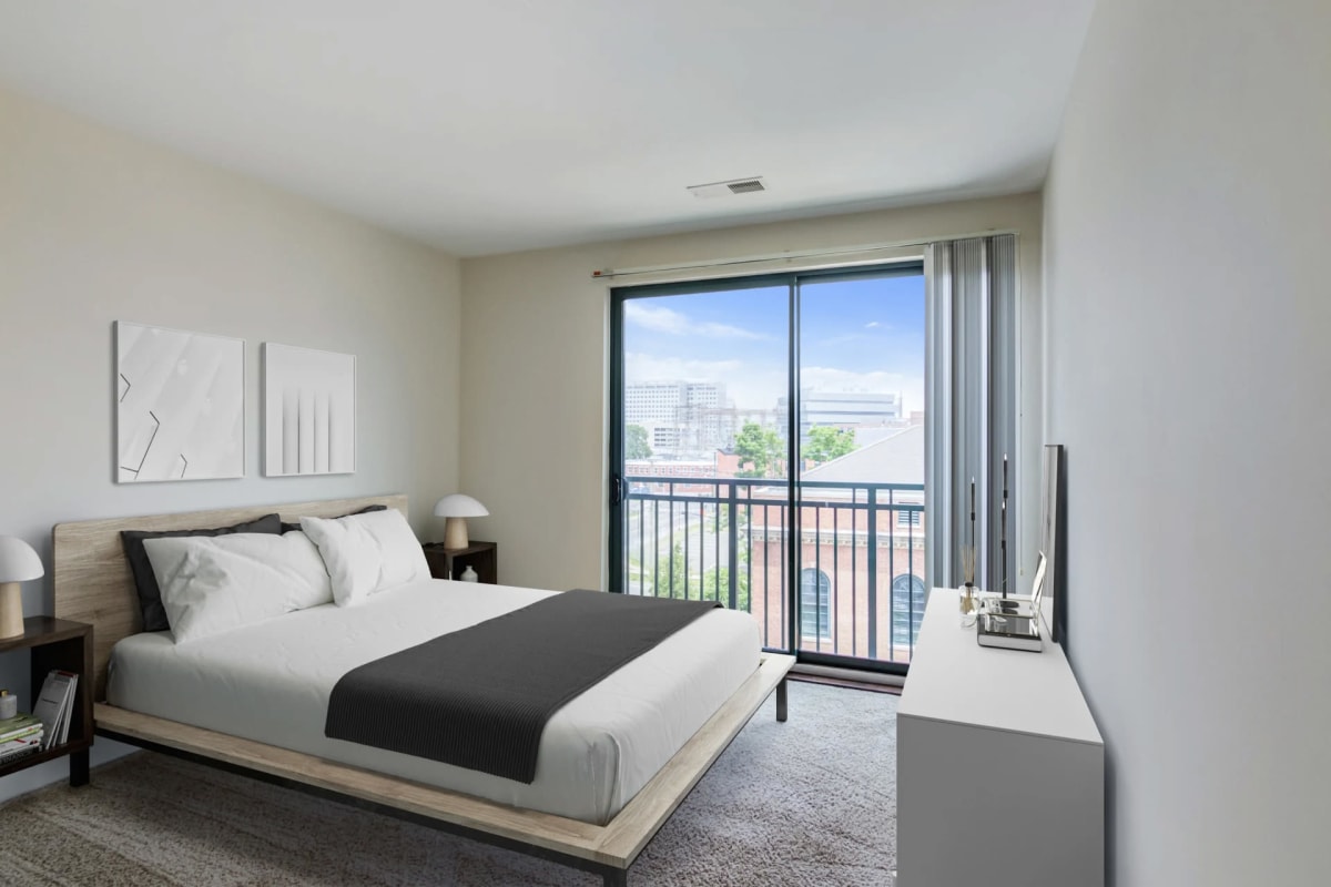 Bedroom with a door to a private balcony at The Key at Yale and Towne in Stamford, Connecticut