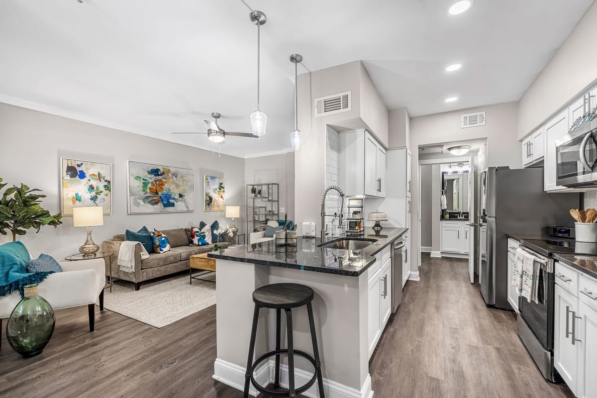 Bright living room and kitchen with wood floors at Marq Perimeter in Atlanta, Georgia