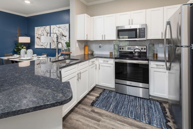 Open concept kitchen with granite countertops in a model home at Mezza in Jacksonville, Florida