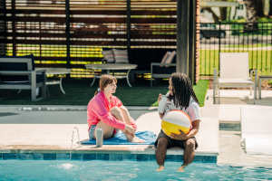 Residents sitting on the edge of a pool at The Waters at Promenade in Marrero, Louisiana