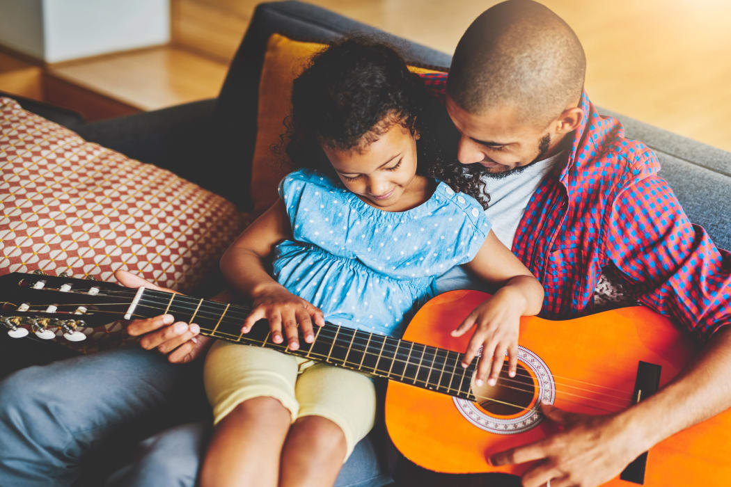 Father teaching his daughter to play guitar at Castlewood Apartments in Walnut Creek, California