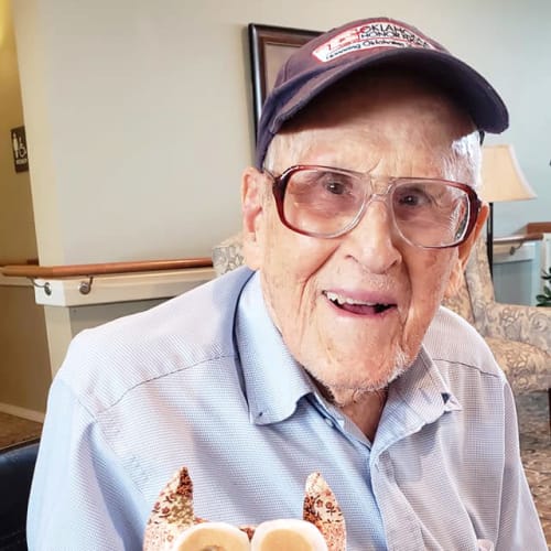 Smiling resident holding an art project at Canoe Brook Assisted Living & Memory Care in Catoosa, Oklahoma