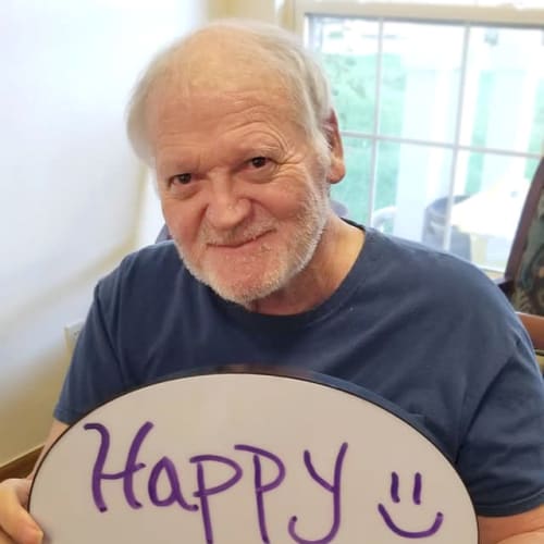 Resident holding up a sign that says 'happy monday' at Creekside Village in Ponca City, Oklahoma