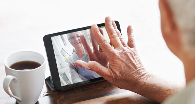 Senior holding tablet at Maplewood at Brewster in Brewster, Massachusetts