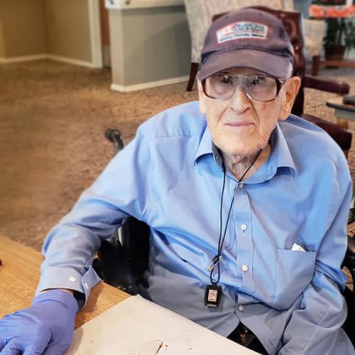 A resident with gloves on decorating cookies at Canoe Brook Assisted Living & Memory Care in Catoosa, Oklahoma