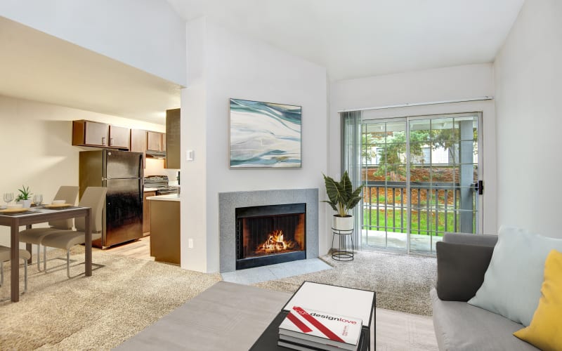 Spacious living room with plush carpeting and a fireplace at Wellington Apartment Homes in Silverdale, Washington