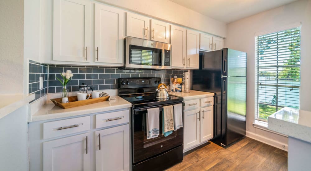 Modern kitchen with great natural lighting and wood-style flooring at Waterside Apartments in Houston, Texas